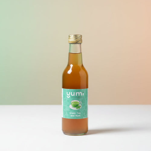 Bottle of 'yumi' green tea and mint on a gradient background